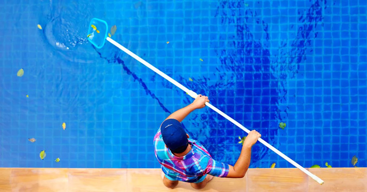 ragazzo che pulisce l'acqua della piscina con una rete