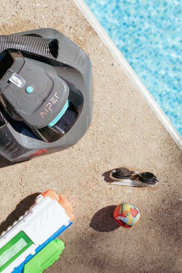 Robot Aiper a bordo piscina con occhiali e pistola ad acqua vicino